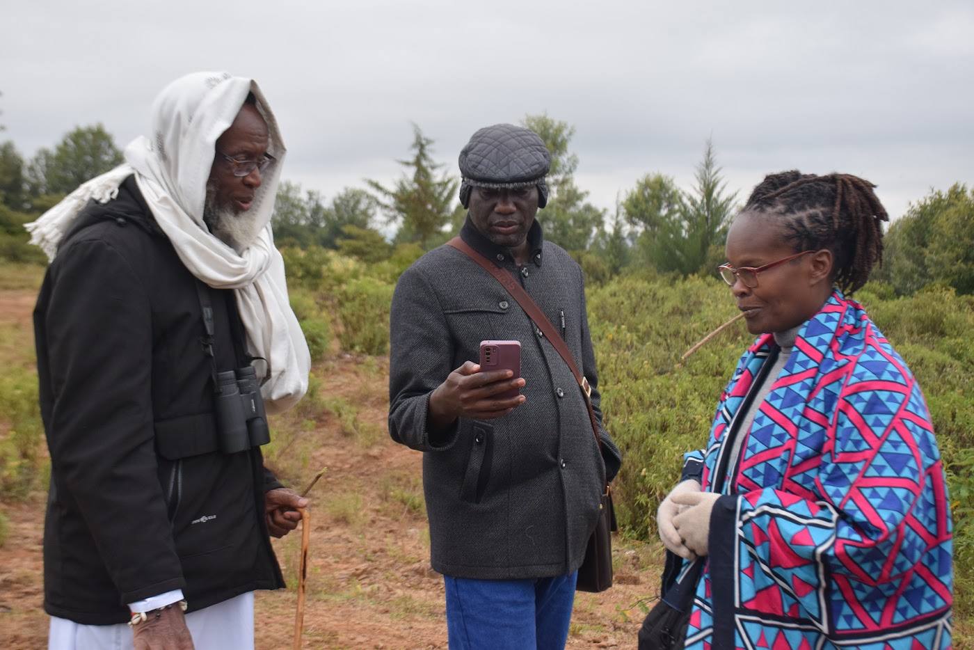 Utu Heritage delegation members in conversation on a hillside at Porini